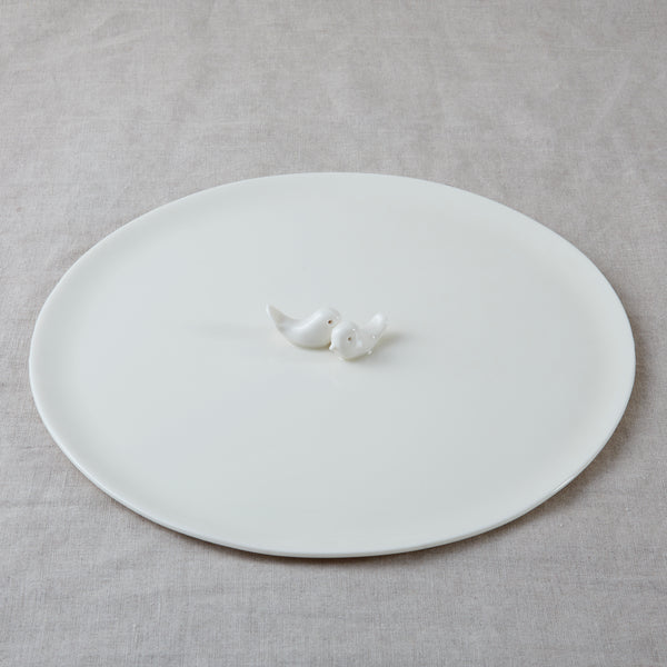 The Side by Side is an exquisitely handcrafted porcelain plate with two hand-sculpted birds facing each other in the center